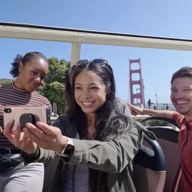 Un grupo de visitantes se toma una selfie en un recorrido en autobús cerca del puente Golden Gate. 加州威尼斯人官网平台app.